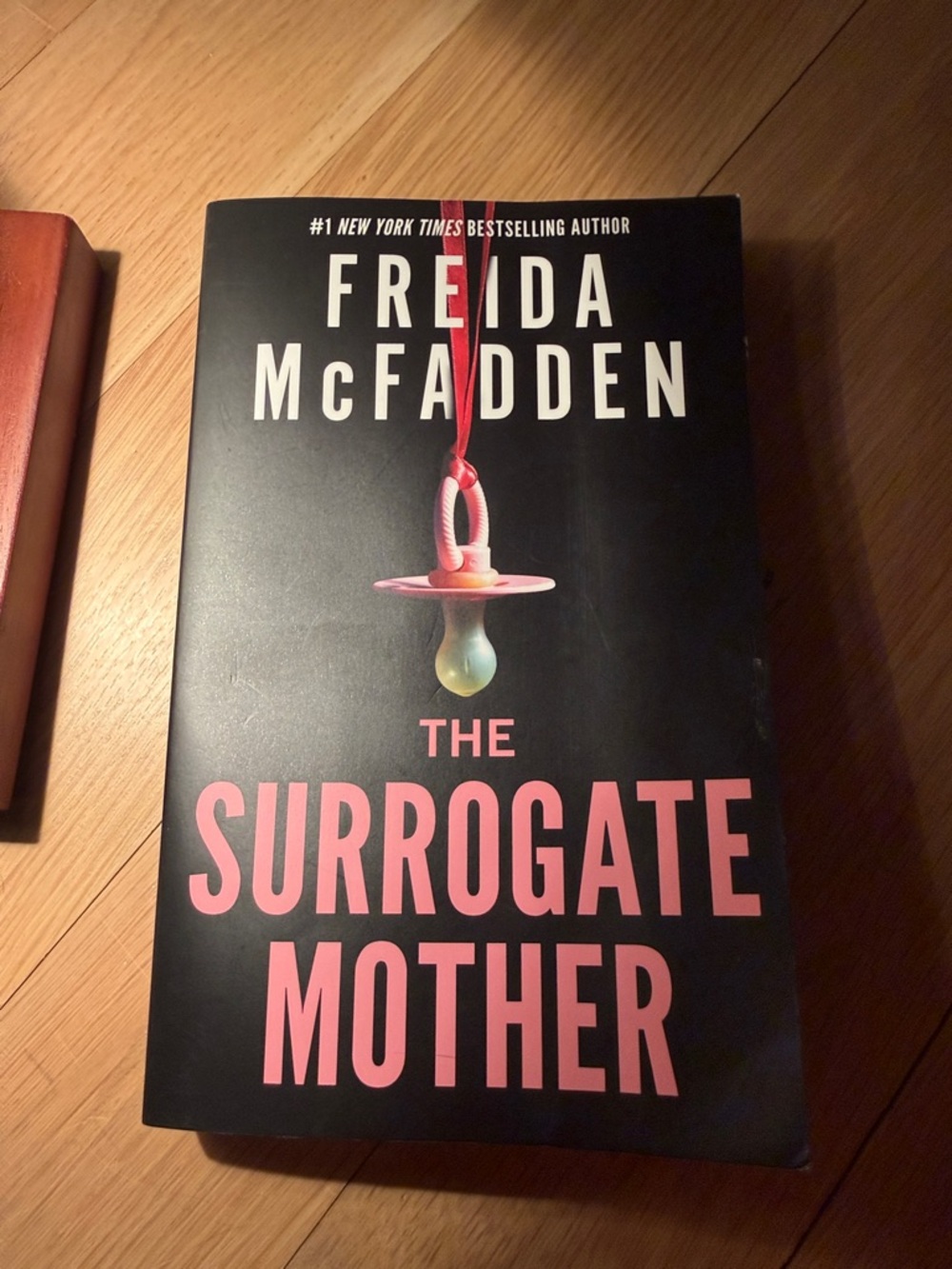 The Surrogate Mother by Freida McFadden - Black with Pink Text